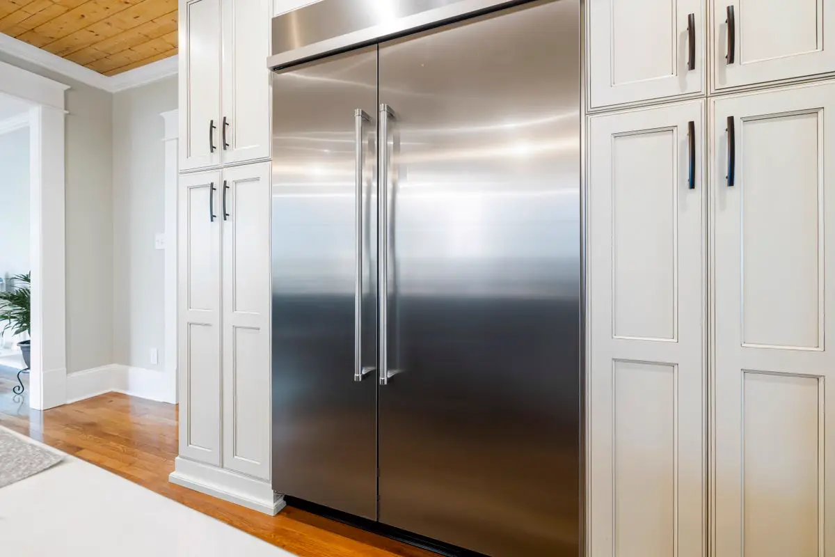 Built-in stainless steel refrigerator in a home kitchen, the kind of unit we see on fridge repair calls in Kingston